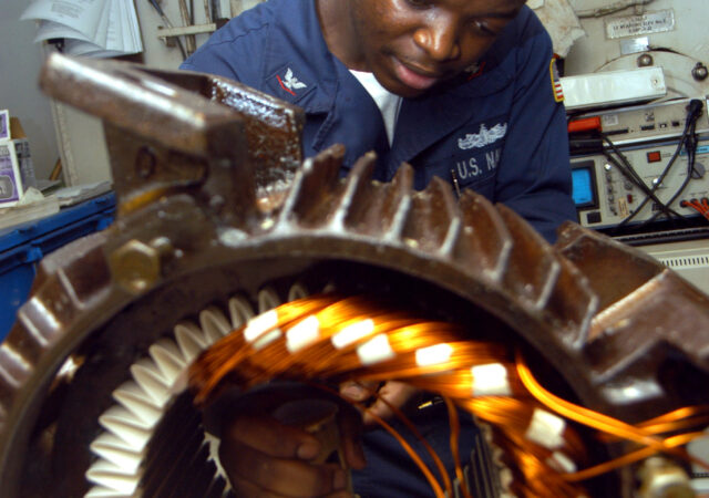 040902-N-7683J-003
Arabian Gulf (Sept. 2, 2004) - Electrician's Mate 3rd Class Tayo Gbadebo from Lagos, Nigeria, rewires the motor from an Aqueous Film Forming Foam (AFFF) Sprinkler SystemÕs pump during a routine maintenance in the Machine Shop aboard the conventionally powered aircraft carrier USS John F Kennedy (CV 67). The machine shop troubleshoots equipment, makes mechanical and electrical repairs  throughout the ship. The Kennedy and Carrier Air Wing Seventeen (CVW-17) are operating in the 5th fleet area of responsibility (AOR) in support of Operation Iraqi Freedom (OIF). Units in the Kennedy Strike Group are working closely with Multi-National Corps-Iraq and Iraqi forces to bring stability to the sovereign government of Iraq. U.S. Navy photo by PhotographerÕs Mate 2nd Class Jason Jacobowitz (RELEASED)